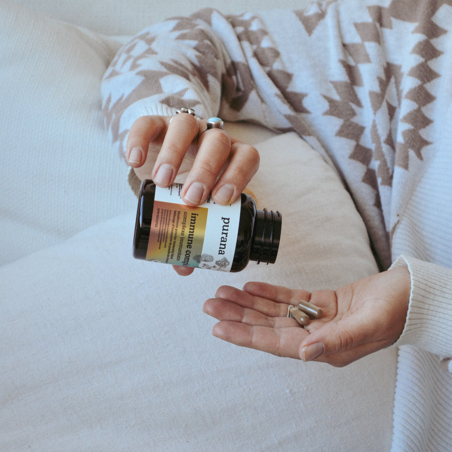Immune complex capsules being poured from a Purana bottle into an open hand