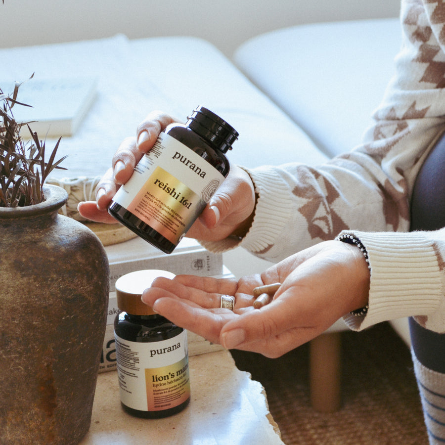 Reishi 16:1 capsules being poured from a Purana bottle into an open hand